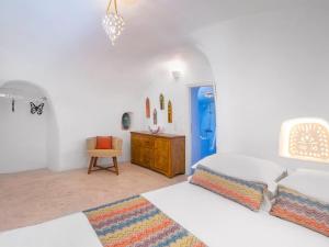 伊亚阿尼米度假屋及别墅的一间白色卧室,配有一张床和一个蓝色的门