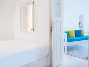 伊亚阿尼米度假屋及别墅的白色的客房设有蓝色的沙发和门