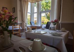 贝图瑟科伊德Mary's Court Guest House - Mairlys的一间用餐室,配有一张带白色桌布的桌子