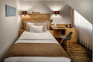 埃斯林根Neo Hotel Linde Esslingen的一间卧室配有一张床、一张桌子和一把椅子
