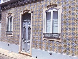 法鲁Terrace Barqueta Studio的建筑上镶有蓝色和黄色的瓷砖