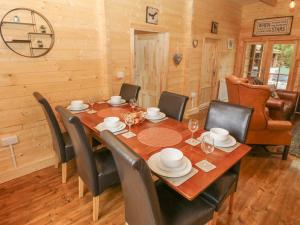 班戈Bryn Derwen Lodge的一间带木桌和椅子的用餐室