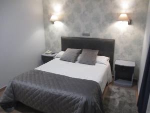 阿维拉莫拉达斯酒店的一间卧室设有一张大床和两个床头柜