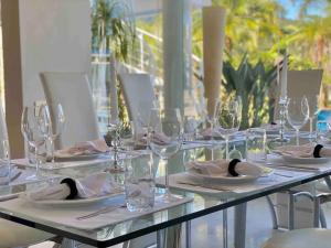 MocoócaCondomínio Costa Verde Tabatinga的长桌,带玻璃杯,盘子和餐巾
