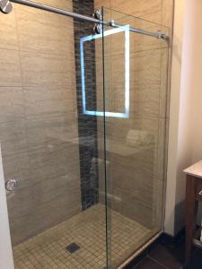 圣安东尼奥温德姆花园河畔步行街博物馆酒店的浴室里设有玻璃门淋浴