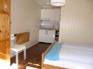 艾菲约德Kvamsdal Pensjonat 3的一间卧室配有一张床铺和一张桌子,还设有一间厨房