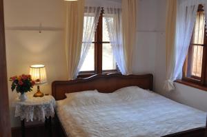 斯克拉斯卡波伦巴Villa Nostalgia的一间卧室配有一张床和一张花瓶桌子