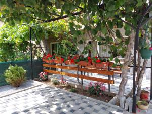 奥赫里德Petroski Apartments的花园里的木凳上种着鲜花