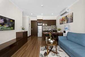 河内Newsky Serviced Apartment的一间带蓝色沙发的客厅和一间厨房