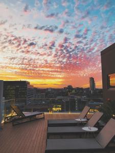 布里斯班亚历克斯佩里酒店及公寓的长凳的建筑屋顶上的日落