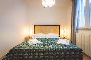 切齐纳码头Via Siena 4 - Suites & Rooms的一间卧室配有一张大床和两个枕头