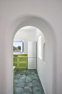 VourvoúlosVilla Rodakes的厨房配有白色冰箱,铺有瓷砖地板。