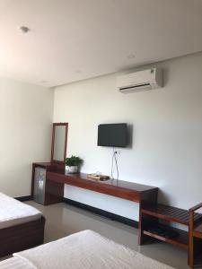 绥和市塔恩拉姆酒店的卧室设有壁挂式电视和床。