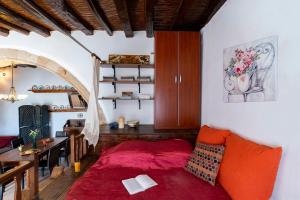 Asklipiḯon1900's traditional house in Asklipio的客厅配有红色的床和桌子