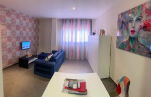雷阿尔城Estudio con piscina y Wifi的客厅配有蓝色沙发和绘画作品