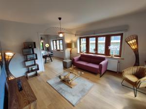 拉罗什-阿登Villa Le Genêt Fleuri的客厅配有紫色沙发和桌子