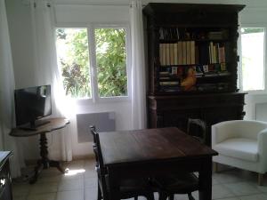 Saint-Georges-Haute-VilleÉrable Pourpre的客厅配有木桌和电视。