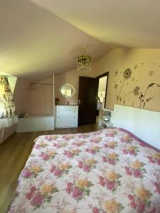 泰拉维Nino's Veranda Apartment的一间卧室配有一张带花卉床罩的大床