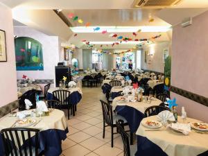 里米尼Albergo Villa Denny的一间带蓝桌布的餐桌的用餐室