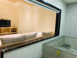 鱼池乡日月潭沅居民宿 YUAN JU BOUTIQUE Hotel的一张床铺和浴缸,房间里的大镜子