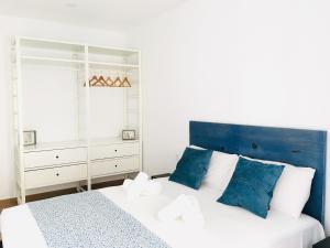 布拉内斯Aiguaneu El Celler的卧室配有蓝色和白色的床和镜子