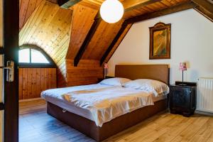 扎马迪Bohém Birtok és Csárda的一间带一张床的卧室,位于带木制天花板的房间内
