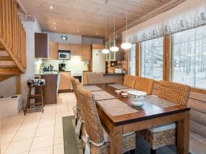 列维Holiday Home Aspilevi by Interhome的厨房以及带木桌和椅子的用餐室。