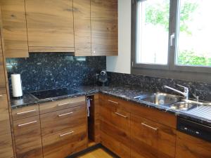 英格堡8号公寓的厨房配有木制橱柜、水槽和窗户。