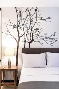 马尼拉马卡蒂阿蒂米斯广场酒店的一间卧室配有一张树墙贴花的床