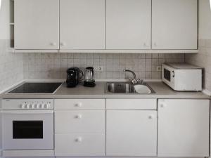 布劳沃斯港Holiday Home Den Osse by Interhome的厨房配有白色橱柜、水槽和微波炉