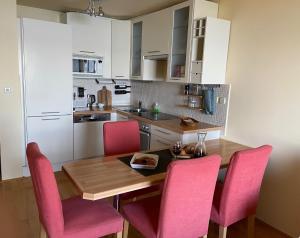 布雷拉Werz Sea View Apartment的厨房配有木桌和粉红色的椅子
