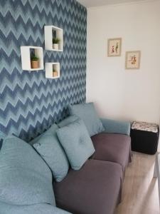 滨海克里耶勒La Houle, maison classée 4 étoiles的客厅配有带蓝色枕头的沙发