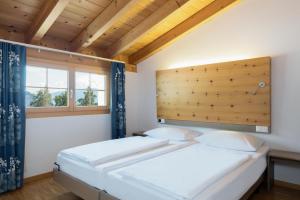 弗利姆斯Hapimag Ferienwohnungen Flims的带窗户的客房内设有两张单人床。