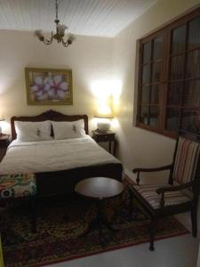 里奥格兰德Hostel Pousada Rheingantz Rio Grande的一间卧室配有一张床、一把椅子和一张桌子