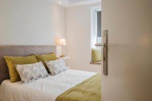 里斯本阿尔法马顶峰公寓的一间卧室配有带白色床单和枕头的床。