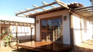 戈亚斯州上帕莱索Vila Gaia Guest House的一座带木门廊和门的小房子