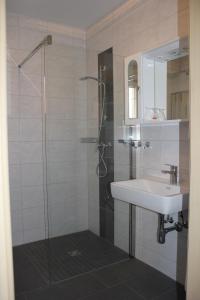Oberwölz Stadt摩尔恩旅馆的一间带玻璃淋浴和水槽的浴室