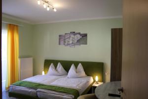 Oberwölz Stadt摩尔恩旅馆的一间卧室配有一张带绿色床头板的床和一张桌子