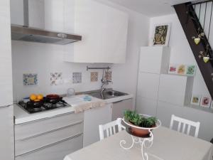 锡拉库扎A casa di Ninuccia的厨房配有白色橱柜和碗桌