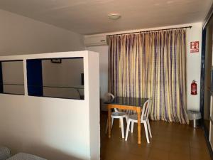 科尼尔-德拉弗龙特拉Hotel Playa Conil的客房设有桌椅和窗户。