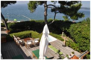 伊佐拉Premium apartment Natura的一个带白色遮阳伞和椅子的庭院和大海