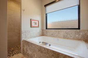 圣乔治Red Rock的带浴缸的浴室和窗户