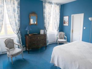 Saint-JulienChâteau de Colombier的蓝色卧室,配有床和两把椅子