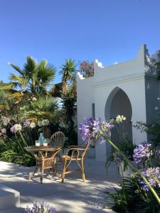 奇克拉纳－德拉弗龙特拉Kasbah Andaluz guest house的庭院配有桌椅和鲜花