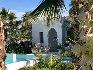 奇克拉纳－德拉弗龙特拉Kasbah Andaluz guest house的一座别墅,设有游泳池和棕榈树