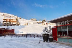 帕克城全季度假旅舍日出酒店的一座白雪覆盖的山,有一座建筑和一个滑雪场