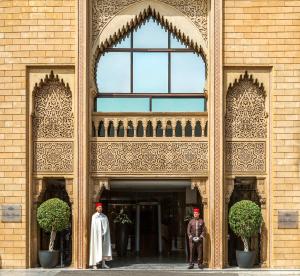 拉巴特拉图尔哈桑宫酒店的身着制服的两个人站在建筑物外面
