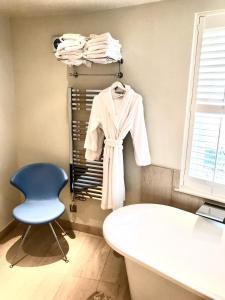切尔滕纳姆校园美景住宿加早餐旅馆的一间房间,配有椅子和架子上的白色浴袍