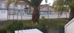 安格雷RESIDENCE LA CROISIERE- Appt Duplex 6 Personnes的一个带游泳池、棕榈树和围栏的度假村