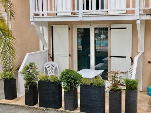安格雷RESIDENCE LA CROISIERE- Appt Duplex 6 Personnes的黑容器中带长凳和植物的门廊